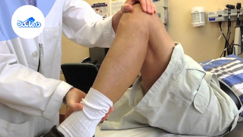 تصویری از پزشک در حال معاینه زانوی فرد بیمار و بررسی عکس زانو.